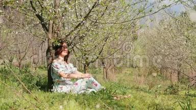 一位年轻的美女，身穿长裙，坐在盛开的<strong>梅树</strong>下