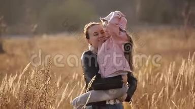 一家人花时间在大自然中，妈妈轻轻地拥抱女儿，美丽的妈妈在和孩子玩耍
