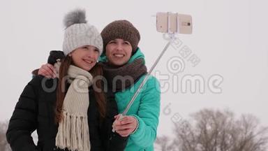 妈妈和女儿在智能手机上拍照，在<strong>圣诞节</strong>早上的冬天公园。 <strong>一家人</strong>在白雪皑皑的树林里休息