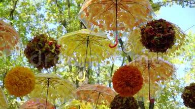 明亮的橙色和黄色的伞和球在风中悬挂和移动