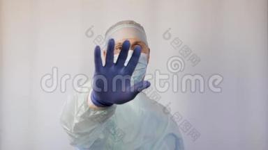 一个戴着医用面罩的外科医生展示了一个手势-停止。<strong>必须</strong>停止。