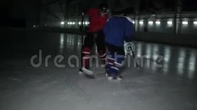 两个人在溜冰场打曲棍球。 两个冰球运动员为冰球而战。