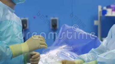 护士帮助外科医生把乳胶手套戴在手上