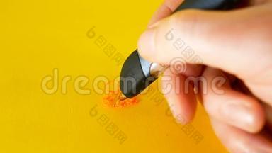 一个男人`用3d打印机笔在黄色背景下画画，这是创新、技术等主题的理想画面