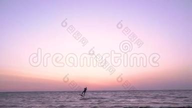 一个人在黎明时从事风筝<strong>冲浪</strong>，并跳入空中，动作缓慢
