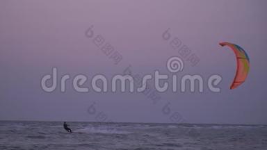慢动作射击男子控制训练风筝在波浪上，在黎明时射击