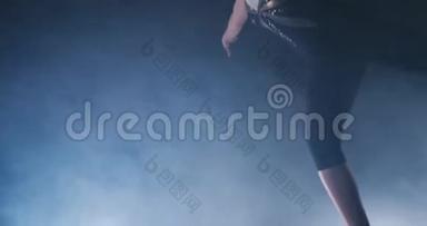 在烟雾中缓慢运动，一个女运动员站着，她的手臂举起后，表<strong>演练</strong>习。 欢迎手势