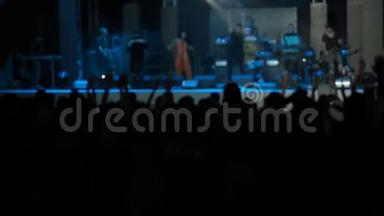 慢动作视频表演者观众跳跃举起手摇滚乐队音乐厅剪影跳舞的人