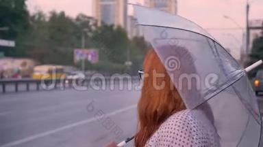 戴眼镜的胖姜女站在公共汽车站，等待公共汽车，打伞