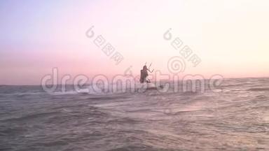 一个女孩在海上风筝在黎明<strong>时</strong>冲浪，慢动作。 泄漏