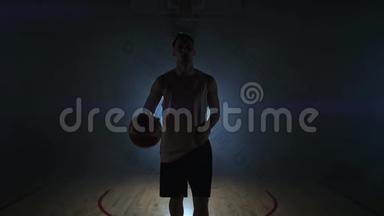 篮球<strong>运动</strong>员走到<strong>摄像机</strong>前，把球敲在地上，然后停下来，拿着球看着