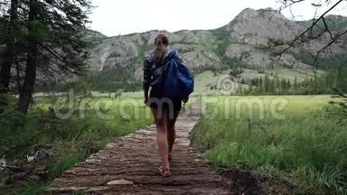 <strong>徒步</strong>旅行。背着背包在山上的桥上行走的女游<strong>客</strong>。<strong>徒步</strong>旅行的冒险。后视图