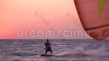 黎明时，男子控制着一只明亮的训练风筝漂浮在海里