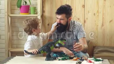 父子俩玩<strong>恐龙</strong>.. 可爱的<strong>小</strong>孩和长胡子的父亲玩塑料<strong>恐龙</strong>。 父亲