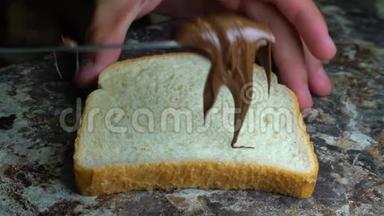 巧克力酱用餐刀铺在面包上做三明治