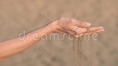 女人的手在沙滩上用手指轻轻地推沙。