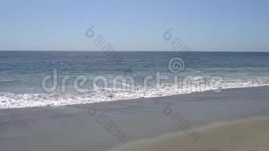 太平洋的波浪在加州马里布海滩的岸边拍打。 沙滩上温暖阳光的夏日