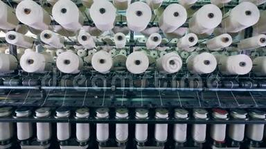 纺织厂在带有线轴的工业机器上进行的裁剪过程。