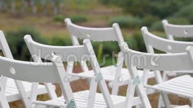 全景式的白色折叠椅在结婚登记区的婚礼上滴着滴