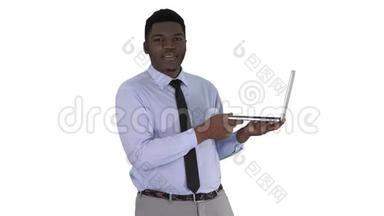 与镜头交谈，年轻的非洲男子手<strong>拿笔</strong>记本电脑在白色背景。