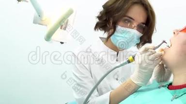 年轻女子坐在牙科椅上做牙医检查。 媒体。 美丽女牙医的侧景