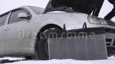 冬天汽车背景上的电池被放电，司机在汽车附近行走，启动时出现问题