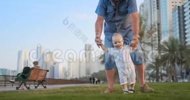 年轻的父亲带着孩子和<strong>第一</strong>步。 年轻的父亲带着孩子在户外学习，在靠近城市的<strong>第一</strong>步