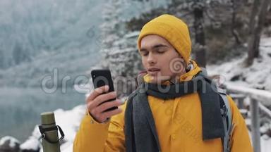 穿着黄色夹克的<strong>年轻</strong>帅哥站在美丽的山上。 徒步旅行者拍摄冬天的自然。 这<strong>就是</strong>