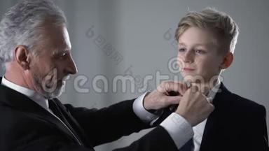 成熟的父亲调整小儿子领带，以孩子为荣，未来的事业接班人