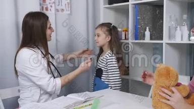 一位女医生为一个小女孩病人检查喉咙痛。 妈妈和小女儿在<strong>招待</strong>会上