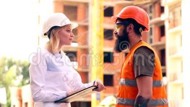 施工负责人与施工现场工人讨论工作细节.. 戴着白色头盔的女人