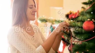 一幅美丽的笑脸女人在客厅装饰圣诞树的画像，上面挂着五颜六色的<strong>花苞</strong>和珠子