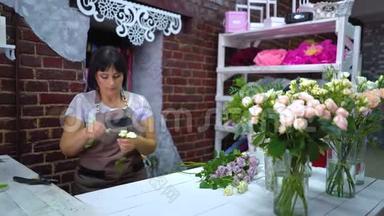 Dolly shot专业花店从干花瓣中挑选和检查白玫瑰枝