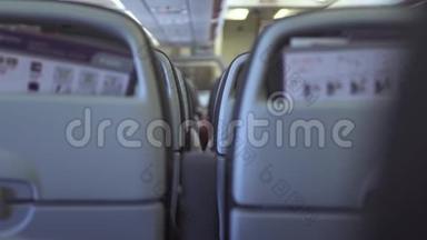 在空中飞行时，乘客坐在机舱内的现代飞机上。 乘坐经济舱商业飞机的乘客座位