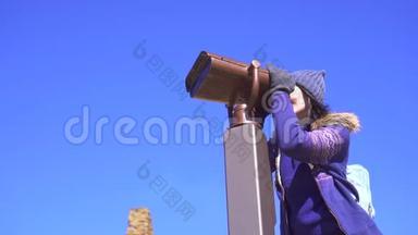 <strong>观景台</strong>上的女孩用望远镜望着群山，慢悠悠地