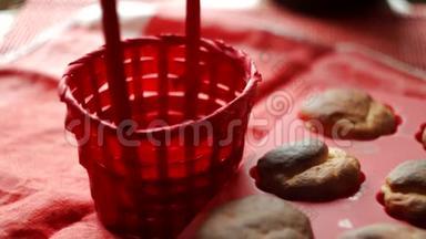 女人把新鲜的松饼放在红色的篮子里
