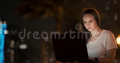 女开发商晚上坐在公园里看着笔记本电脑屏幕写代码