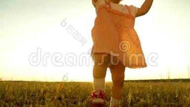 小孩子在草坪上的夏天公园里迈出第一步，笑着笑着。 婴儿被阳光照亮。 慢动作。