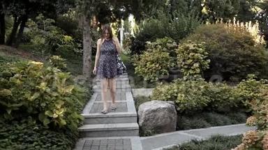 一个年轻的女孩走下美丽的<strong>台阶</strong>，这<strong>台阶</strong>位于一个有各种奇花异草和树木的绿色公园里