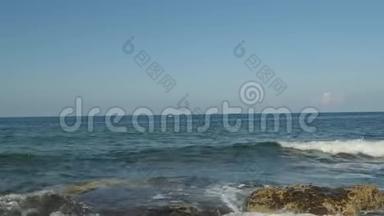 塞浦路斯美好夏日的晨景。 泡沫光滑的波浪拍打在岩石上，干净的水，清晰的地平线。