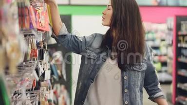 爱的母亲正在为她的孩子挑选生日蜡烛`她正在看商店里陈列的商品，还在抚摸着她