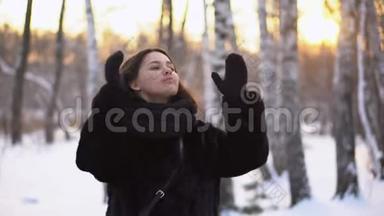 冬天，女人在公园里理发。 年轻有魅力的女人在树林和树林的背景下冷冷地理<strong>直发</strong>