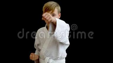 一位穿着白色和服的年轻<strong>运动</strong>员用右手打拳。 男孩用一只手臂环住<strong>腰部</strong>，