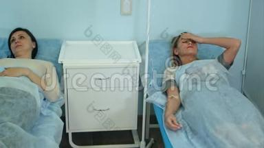 两名女病人躺在医院病房病床上，由男医生检查