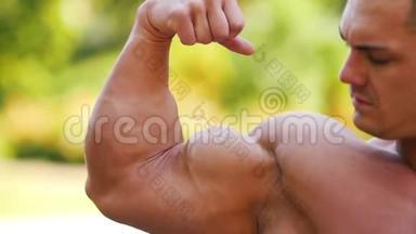 强壮的肌肉男运动员展示他的大二头肌