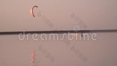 橙色风筝，一个人在平静的湖面上滑行。 慢动作