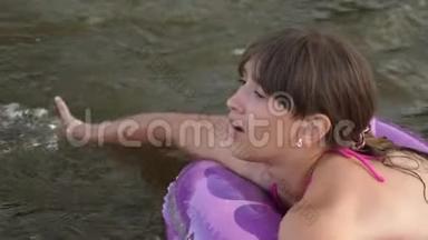 穿着<strong>泳装</strong>的瘦小女孩在救生圈的水面上漂下河，笑了起来。 <strong>海滩</strong>季节