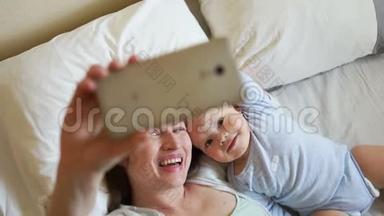 妈妈和宝宝在床上。 家庭早晨快乐。 母亲和父母的概念
