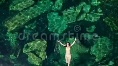 年轻的黑发女人在墨西哥的一个自然的塞诺特游<strong>泳池里</strong>漂浮和<strong>玩耍</strong>。