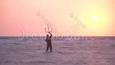 一个穿着潜水服的人拿着一只训练风筝的拖绳，站在尾板上